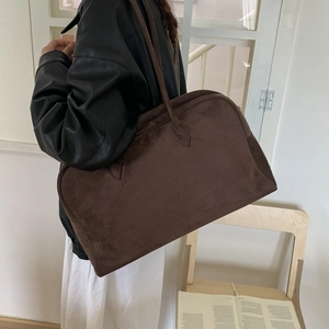 Détail du grand sac bandoulière en daim marron foncé montrant sa texture douce