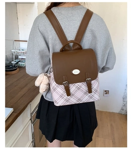 Detail of pink plaid backpack with brown leather flap and cute rabbit logo emblem