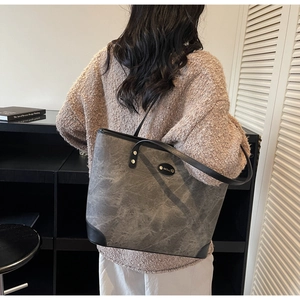 Detail view of large tote bag with grey marble texture and black leather trim accents
