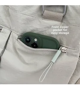Close-up of front zipper pocket on large canvas tote bag showing smartphone storage space
