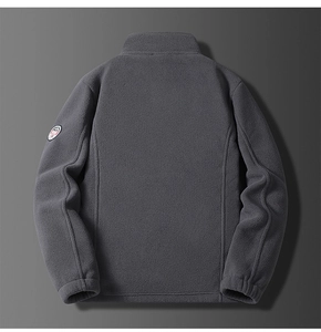 Detail view of the back of a dark gray fleece jacket with a circular sleeve badge
