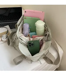 Interior view showing large capacity of the light green nylon tote with daily essentials