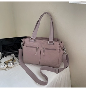Detailed view of Morandi pink nylon tote bag with functional pockets and adjustable strap