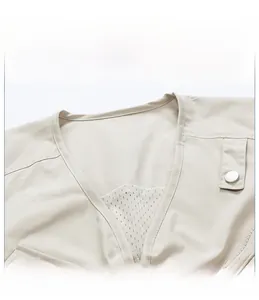 Close-up of beige cargo vest V-neckline with breathable mesh lining and metal buckle