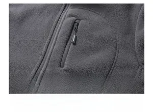Detail display of a vertical chest zipper pocket on a thick dark gray fleece jacket for men