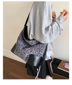 Detail of leopard print tote bag with black leather base and silver metal hardware