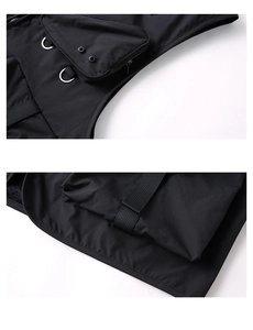 Detail of black tactical outdoor vest showing ripstop fabric and reinforced pockets