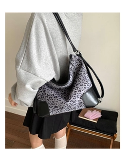 Detail of purple leopard print tote bag featuring leather straps and spacious interior