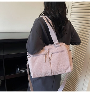 Detail of lavender nylon tote bag with dual front zippers and adjustable shoulder straps
