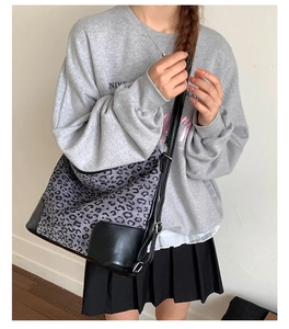 Detail of large leopard print hobo bag showing canvas leather texture and shoulder strap