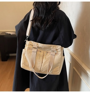 Detail of cream beige canvas tote bag with multi-pocket design and crossbody strap