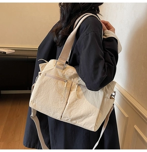 Close-up of cream canvas tote bag showing high-density nylon texture and dual zip pockets