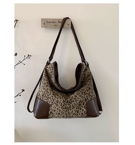 Detail of leopard print canvas and brown faux leather patchwork on a hobo shoulder bag