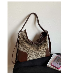 Detail view of large leopard print hobo bag with brown leather handles and stitching