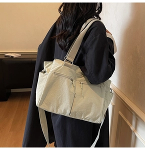 Detail of the large capacity tote bag with wide fabric strap and multiple pockets