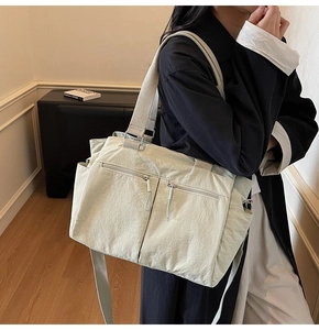 Detail of light green waterproof nylon tote featuring multiple pockets and wide straps