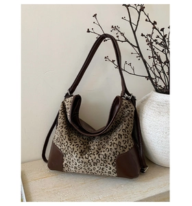 Leopard print bucket bag on marble surface with brown faux leather trim and strap detail