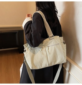 Detail of light green multi-pocket canvas tote bag with adjustable shoulder strap