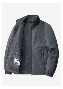 Detail view of dark grey windbreaker featuring inner mesh lining and vertical zip pocket