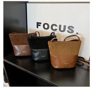 Detail of three bucket bags in dark coffee, black, and camel with suede splicing textures