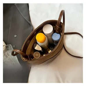 Top view of brown patchwork bucket bag showing spacious interior with personal cosmetics