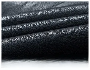 Close-up of black faux leather fabric with litchi texture on a slim biker jacket