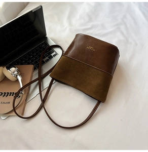 Detail of vintage brown bucket bag with smooth leather and suede patchwork design