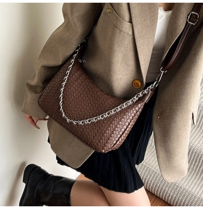 Detail of dark brown woven leather hobo bag featuring silver chain and strap on model