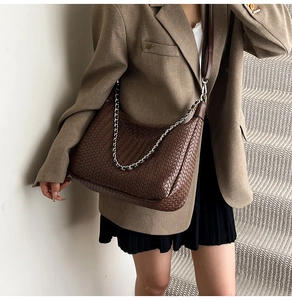 Détail du sac hobo tressé marron foncé avec chaîne argentée et bandoulière en cuir