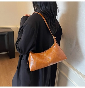 Détail du sac porté épaule marron caramel brillant avec coutures verticales en trois segments