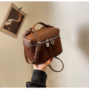 Detail of brown box bag with textured litchi leather and soft suede finish