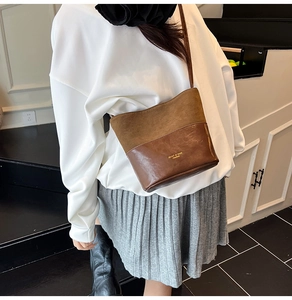 Detail of vintage brown bucket bag showing mixed matte and glossy leather textures
