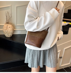 Detail of brown patchwork crossbody bag showing suede and smooth leather textures