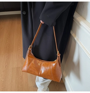 Détail du sac bandoulière marron vintage avec cuir plissé brillant et garniture dorée