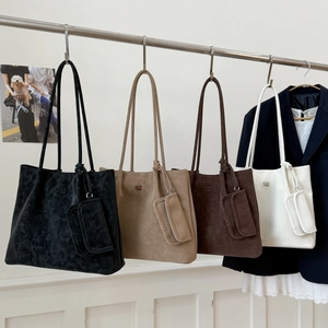 Detail of four matte leather tote bags with matching coin purses in professional office setting