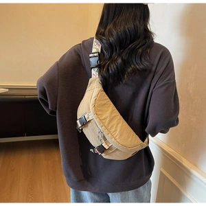 Detail of khaki canvas chest bag with floral pattern strap and durable plastic buckle