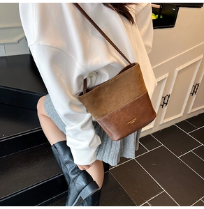 Detail of a brown patchwork bucket bag with suede and smooth leather finishes