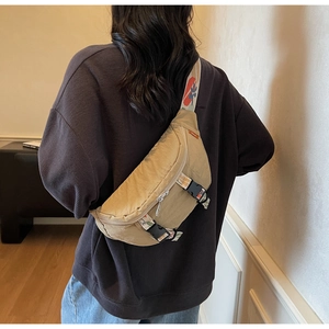 Outdoor khaki canvas crossbody chest bag shown from back with adjustable woven strap