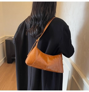 Vue détaillée d'un sac à bandoulière marron vintage avec sangle réglable sur un modèle