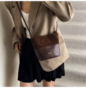 Detail of vintage bucket bag featuring textured suede and smooth leather patchwork