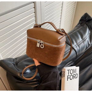 Detail of brown leather and suede paneling on small box bag with silver hardware