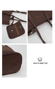 Detail view of dark brown tote bag with matte cracked texture and knot shoulder strap
