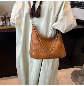 Close-up of brown woven leather shoulder bag with metallic chain and strap details