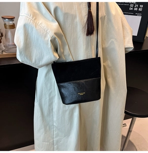 Detailed view of black patchwork bucket bag featuring matte and smooth leather texture