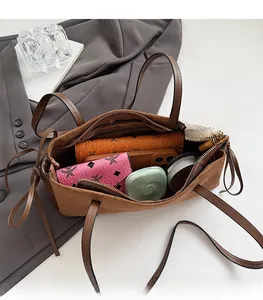 Macro shot showing the spacious interior of a brown suede tote bag with daily essentials