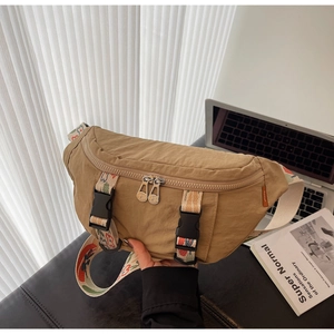 Detail showing durable khaki nylon fabric with silver metal zippers and embroidered strap