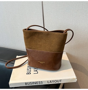 Detail of two-tone bucket bag with brown suede and smooth leather texture finish