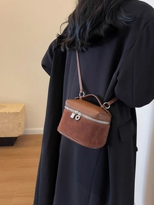 Mini retro brown dual-texture crossbody bag with top handle shown on a model