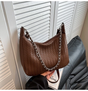 Detail of coffee woven texture hobo bag with silver chain strap and leather handle