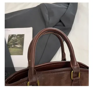 Close-up of the vintage dark brown leather handle with bronze metal hardware and stitching